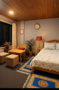 een slaapkamer met een bed, een stoel en een tafel bij The Sunset Nest offbeat Homestay in Darjeeling