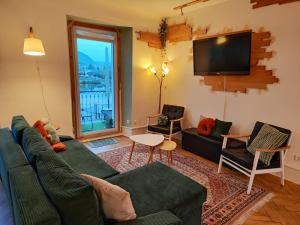 Una sala de estar con un sofá y un televisor de pantalla plana. en Voll ausgestattete Wohnung mit Moselblick, en Alf