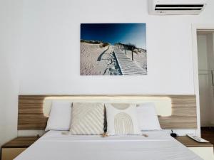 a bedroom with a bed and a picture of a beach at Alojamiento Vacacional con balcón La Vela in Puerto Calero +42 photos