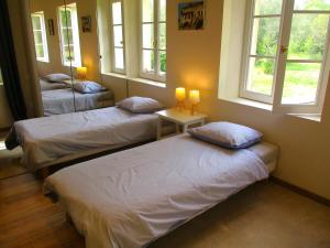 two beds in a room with two windows at Le mas des Lilas in Uzès +79 photos