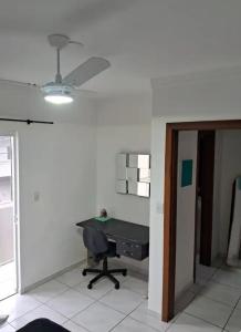an empty room with a desk and a ceiling fan at Lar Suave Lar in Florianópolis