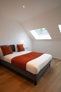 een witte slaapkamer met een bed en een dakraam bij Appartment Douvres 7 in Brussel +44 foto's