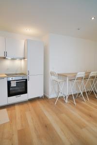 een keuken met witte kasten en een tafel en stoelen bij Appartment Douvres 7 in Brussel