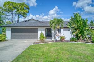 a house with a garage and palm trees at Villa with Pool Home and Outdoor space! in Cape Coral