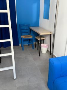 a room with a table and chairs and a blue wall at BLUE Cabin-Larnaca Centrum in Larnaka