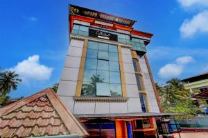 a tall building with a sign on it at Collection O Govt Engineering College Formerly Anby Plaza in Kazhakuttam