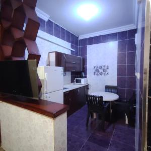 eine kleine Küche mit einem kleinen Tisch und eine Küche mit einem Kühlschrank in der Unterkunft شقق ترف الليل للشقق المخدومة in Ash Shuqayq