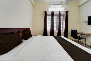 a bedroom with a large bed with a desk and a window at Collection O Govt Engineering College Formerly Anby Plaza in Trivandrum