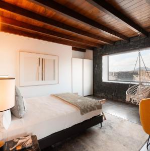 a bedroom with a large bed and a large window at Canaryislandshost I Viñedos in Uga