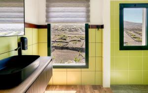 a bathroom with a black sink and a window at Canaryislandshost I Viñedos in Uga +17 photos