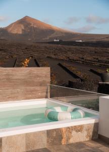 a swimming pool on top of a building with a mountain at Canaryislandshost I Viñedos in Uga
