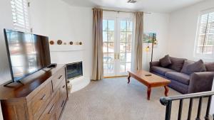 uma sala de estar com uma televisão e um sofá em SV003 Upstairs Studio Spa Villa in LQ Resort em La Quinta