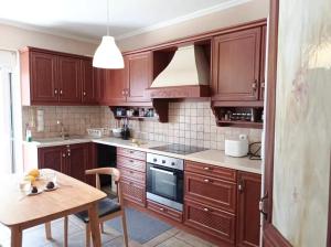 a kitchen with wooden cabinets and a wooden table with a tableablish at Villa Lynn in Athens