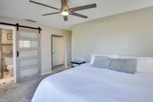 une chambre avec un lit blanc avec un ventilateur de plafond dans l'établissement Bright Ormond Beach Home about 14 Mi to Daytona!, à Ormond-by-the-Sea