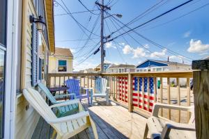 une terrasse avec des chaises, une table et des planches de surf dans l'établissement Cozy Hampton Cottage - Walk to Beaches and Marina!, à Hampton Beach