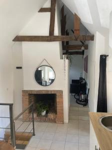 een woonkamer met een open haard en een spiegel bij Le souplex in Nuillé-sur-Vicoin