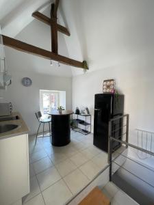 een keuken met een zwarte koelkast en een tafel bij Le souplex in Nuillé-sur-Vicoin +1 foto