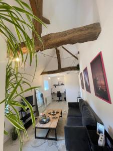 een woonkamer met een zwarte bank en een tafel bij Le souplex in Nuillé-sur-Vicoin