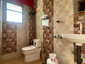 a bathroom with a toilet and a sink at Royal Paradise Inn in Chidambaram +1 photo