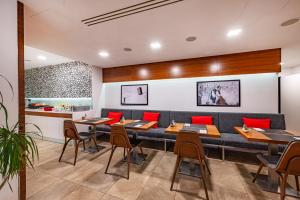a dining room with tables and red chairs at B&B Villa Hotel in Mariánské Lázně