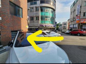 due auto parcheggiate su una strada con una x gialla sul parabrezza di The Cozy Incheon Retreat a Incheon