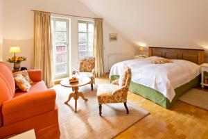 Schlafzimmer mit einem Bett, einem Tisch und Stühlen in der Unterkunft Romantik Hotel Landhaus Bärenmühle in Frankenau