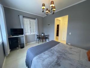 Un dormitorio con una cama y una mesa dentro. en Vila de Charme Suítes, en Campos do Jordão