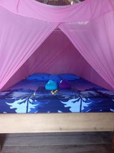 una carpa rosa con dos barcos en el agua en Tanjungmansuarhomestay, en Poelau Mansoear