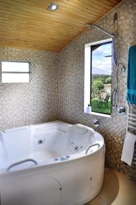 a white bath tub in a bathroom with a window at A Cabanha in Caçador