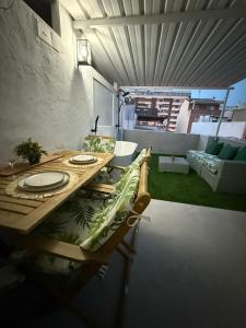 een houten tafel met borden in de woonkamer bij Duplex Ático con terraza y BBQ in Puerto de Sagunto