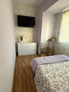 een slaapkamer met een bed en een tv aan de muur bij Duplex Ático con terraza y BBQ in Puerto de Sagunto