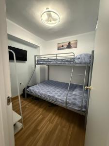 een kamer met twee stapelbedden en een televisie bij Duplex Ático con terraza y BBQ in Puerto de Sagunto