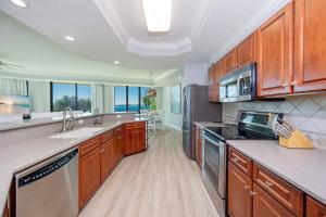 a kitchen with wooden cabinets and stainless steel appliances at Phoenix on the Bay 1134 condo in Caswell +54 photos