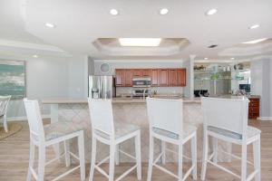 a kitchen with white chairs and a kitchen island at Phoenix on the Bay 1134 condo in Caswell