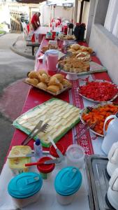 a long table with food and plates of food at Hospedagem Santa Gertrudes Comensoli in Cachoeira Paulista