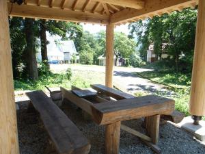猪苗代町にあるCottage All Resort Service / Vacation STAY 8419の木造の櫓の下に座る木製のベンチ