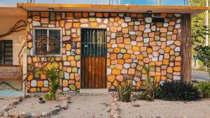 une maison faite de pierres et une porte dans l'établissement Casa Hijos del Cocho Bacalar, à Bacalar