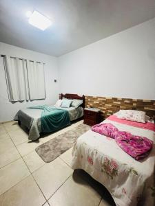 a bedroom with two beds in a room at Casa design Piri no centro de Pirenópolis in Pirenópolis +48 photos