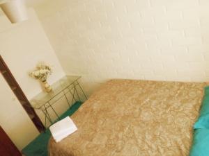 a small bedroom with a bed and a glass table at Alojamiento Rústic in Santiago