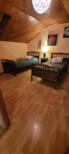 Habitación grande con 2 camas y suelo de madera. en Maison idéal court séjour, en Damblain