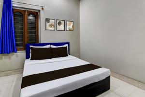 a bedroom with a black and white bed with a blue headboard at Hotel O Green Eco Space in Devanandapur