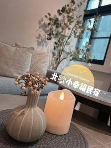 een kaars en een vaas met een bloem in een woonkamer bij Minilove Homestay in Tainan