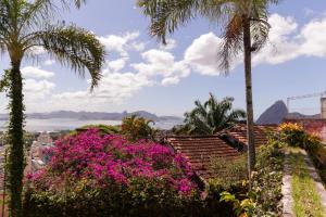 un jardin avec des fleurs roses et des palmiers dans l'établissement Villa St Teresa do Porto: HarboursideVilla-SeaViews-Pool-BBQ-StarLink-6Bedrm, à Rio de Janeiro