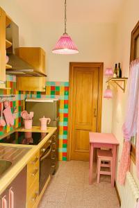 a kitchen with a pink table and a pink stool at REALE COLOSSEO TREVI HOME - private garden in Rome