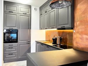 a kitchen with gray cabinets and a sink at White Marble in Black Pearl Chic City Centre in Szczecin