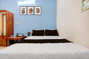una camera con un letto bianco e una parete blu di Hotel O R R Comforts Boarding and Lodging a Nelamangala