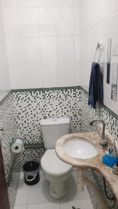 ein Badezimmer mit Toilette und Waschbecken in der Unterkunft Condomínio Maria Clara II in Lauro de Freitas + 14 Fotos