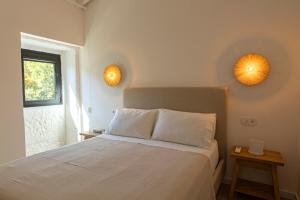 a bedroom with a bed with two lights on the wall at Casa das Costinhas in Loureda +12 photos
