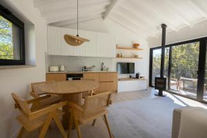 a kitchen and dining room with a table and chairs at Casa das Costinhas in Loureda