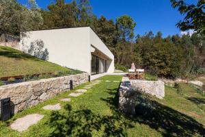 a house on a hill with a stone wall at Casa das Costinhas in Loureda
